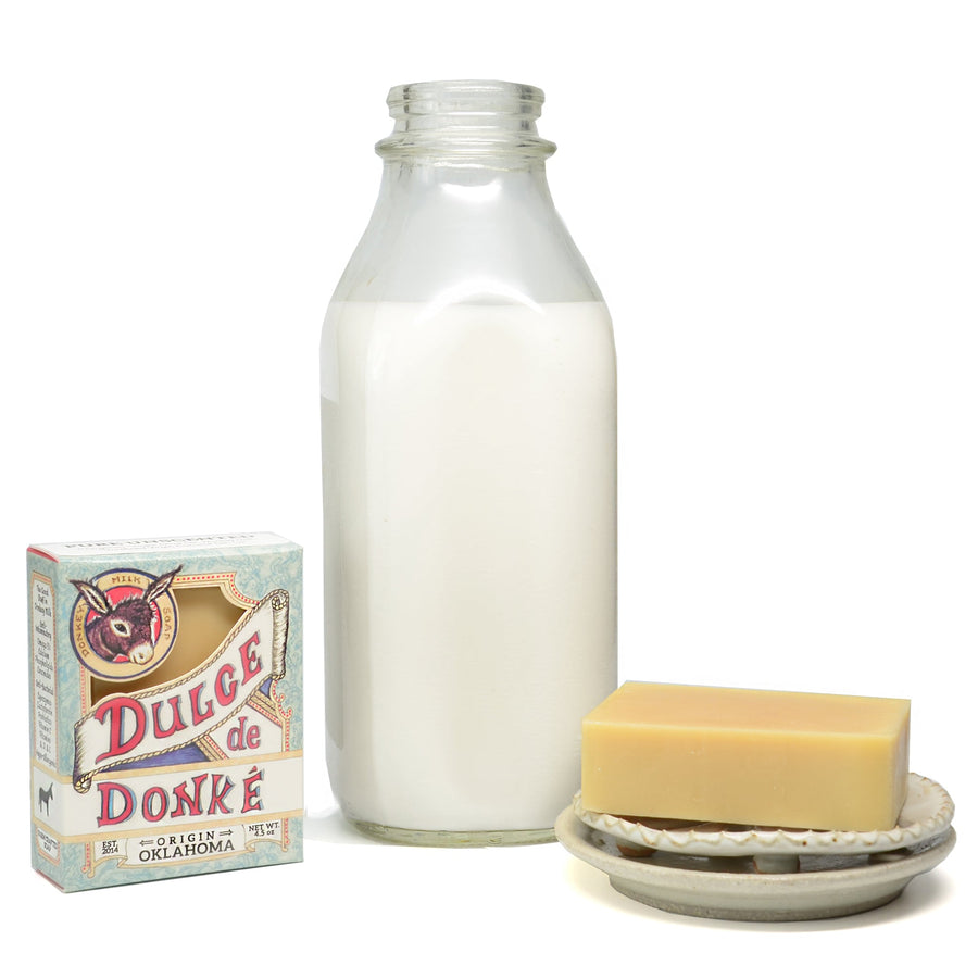 Unscented soap with its package and a milk bottle on a white background