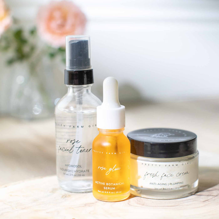 Rose toner, Rose Glow serum and Fresh Face cream on a stone tray