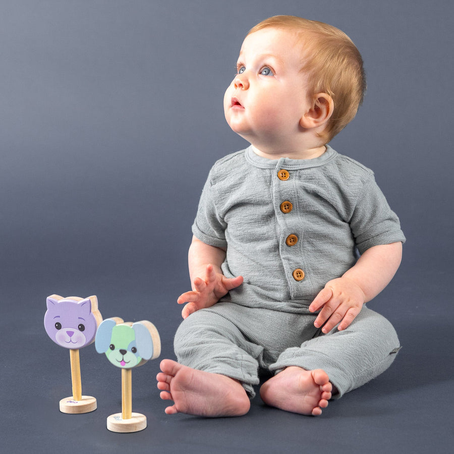 Child playing with dog and cat wooden baby rattles