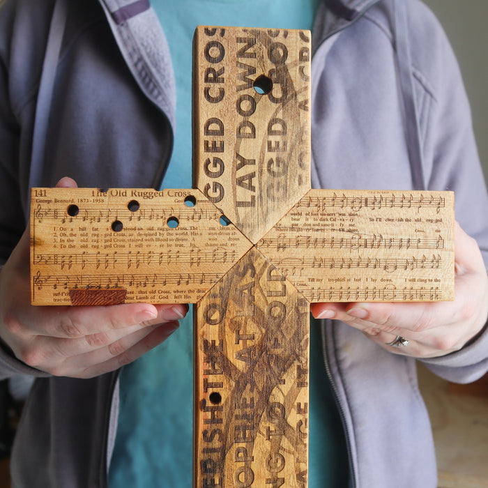 Reclaimed piano wood cross engraved with Old Rugged Cross hymn imagery.