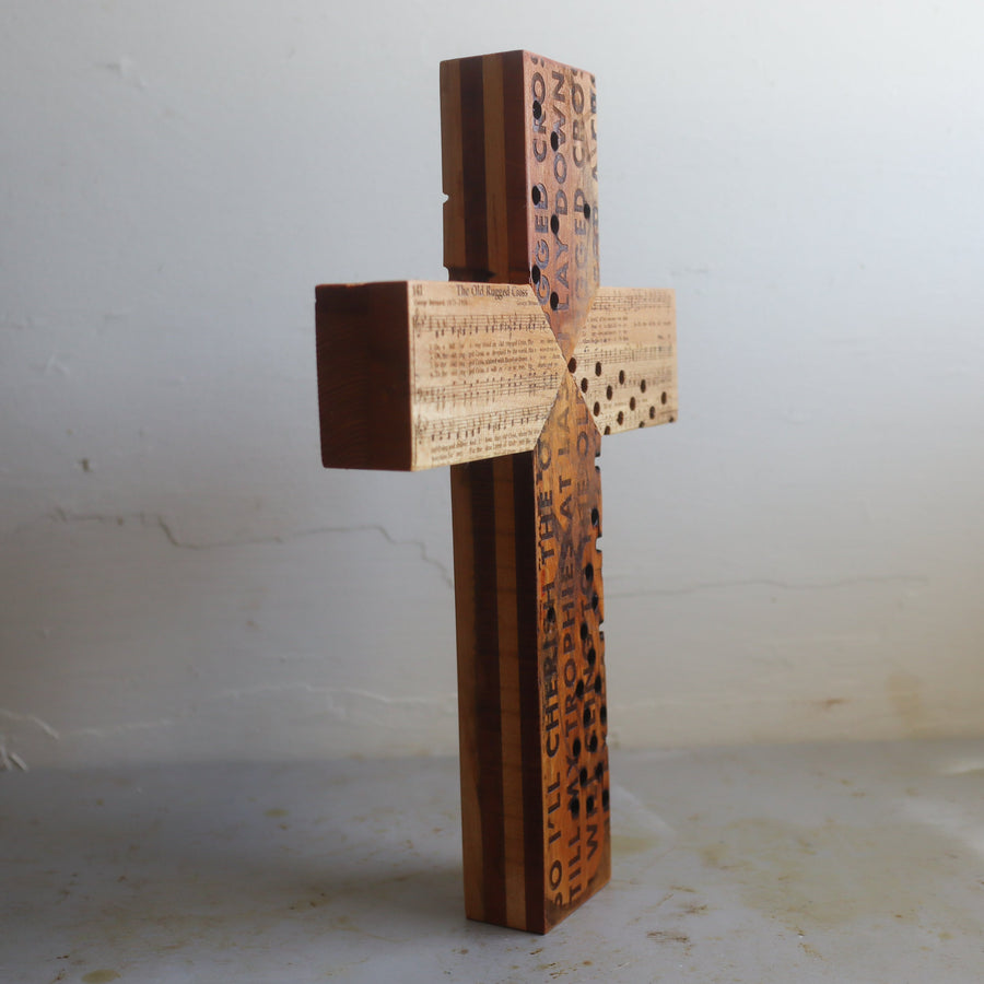 Reclaimed piano wood cross engraved with Old Rugged Cross hymn imagery.