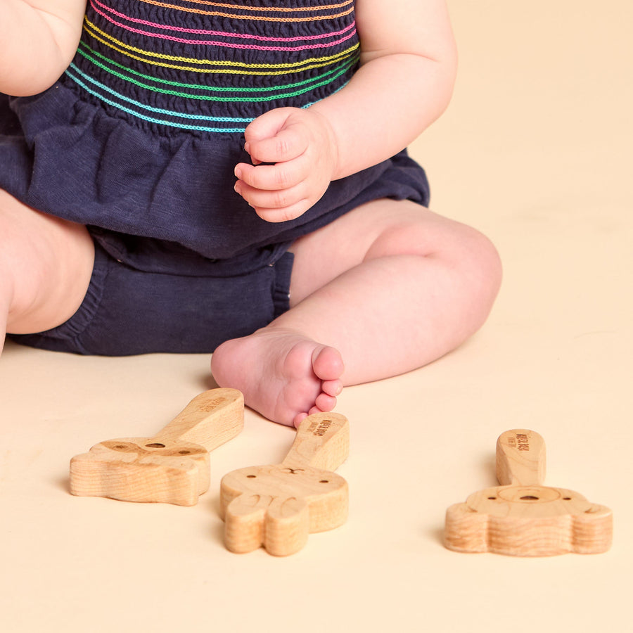 Child holding a wooden animal rattle during a play session