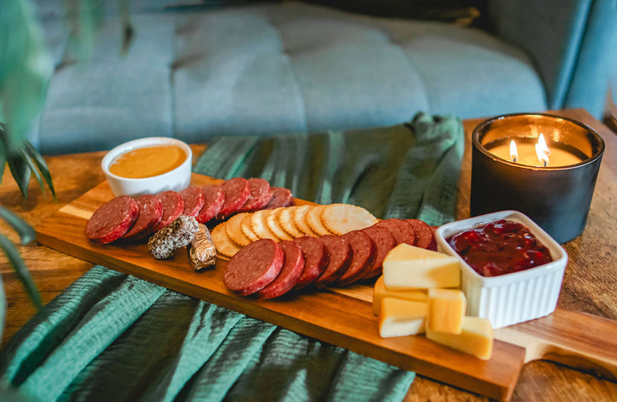 Sliced sausage, cheese, crackers, mustard and lingonberry spread on a board; serving suggestion