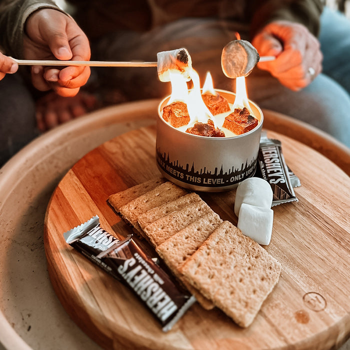 Marshmallow roasting above a separate bonfire beside kit ingredients