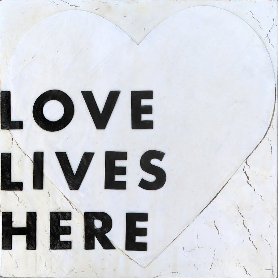 Love Lives Here art print with bold black lettering inside a heart outline.
