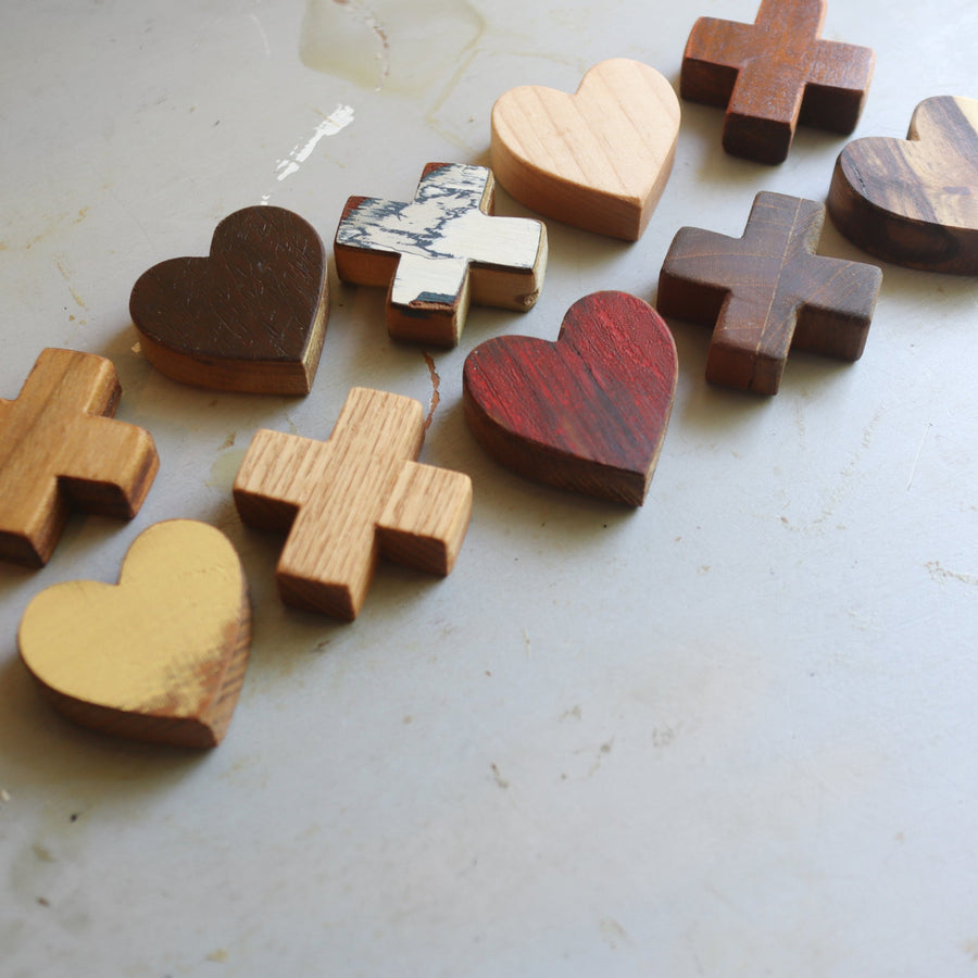 Wooden tic-tac-toe board with heart and X playing pieces.