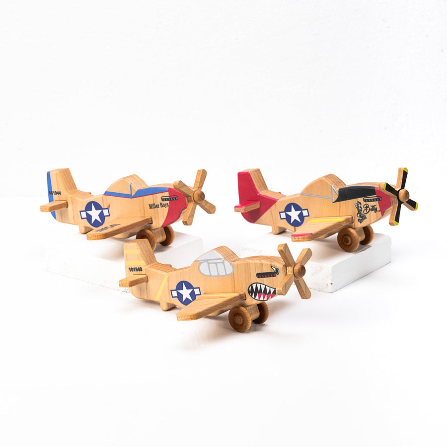 Three wooden P-51-style toy airplanes arranged together