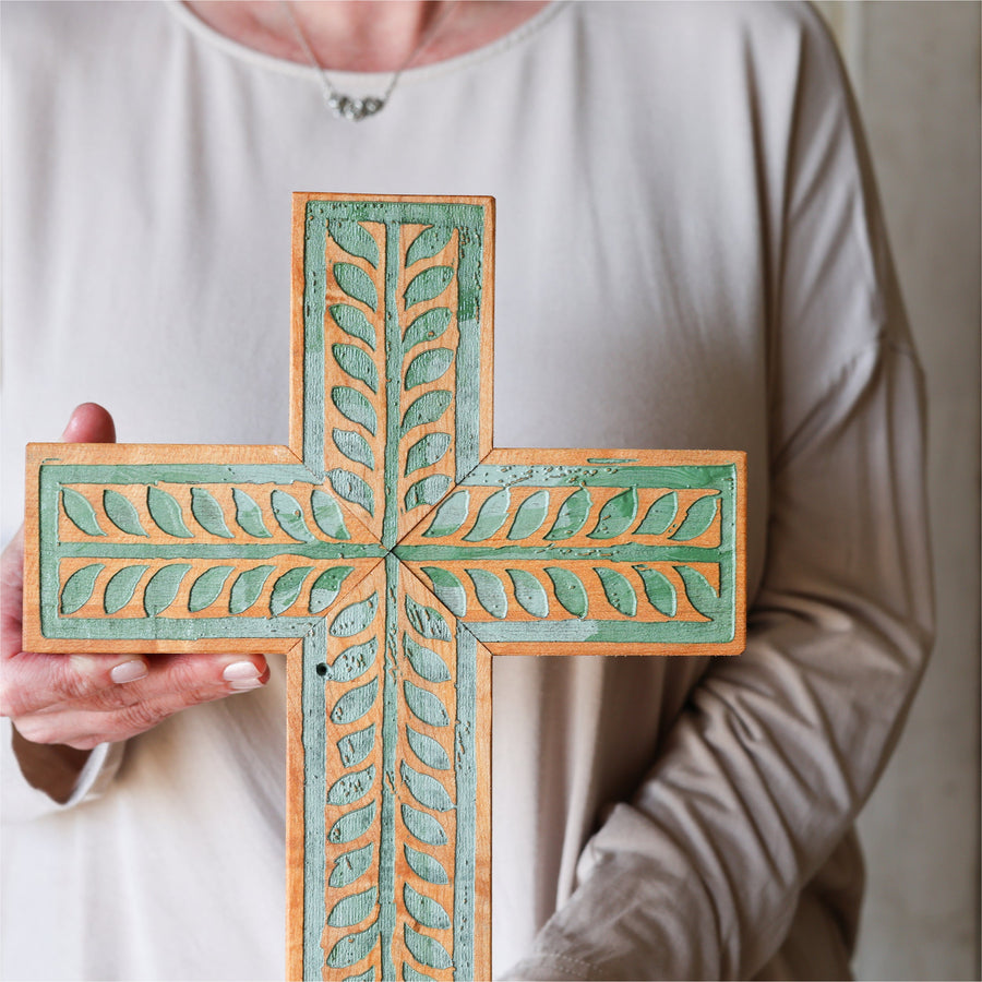 Piano wood cross engraved and painted with a turquoise vine illustration.