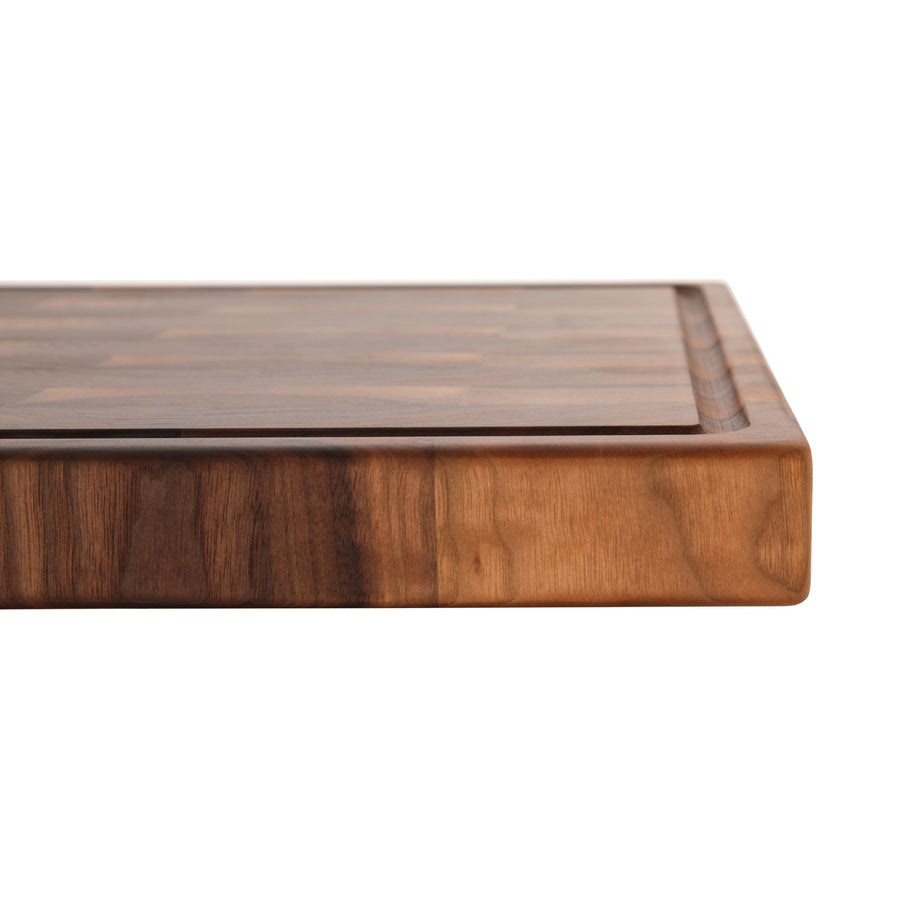 Close side view of a thick walnut end-grain cutting board
