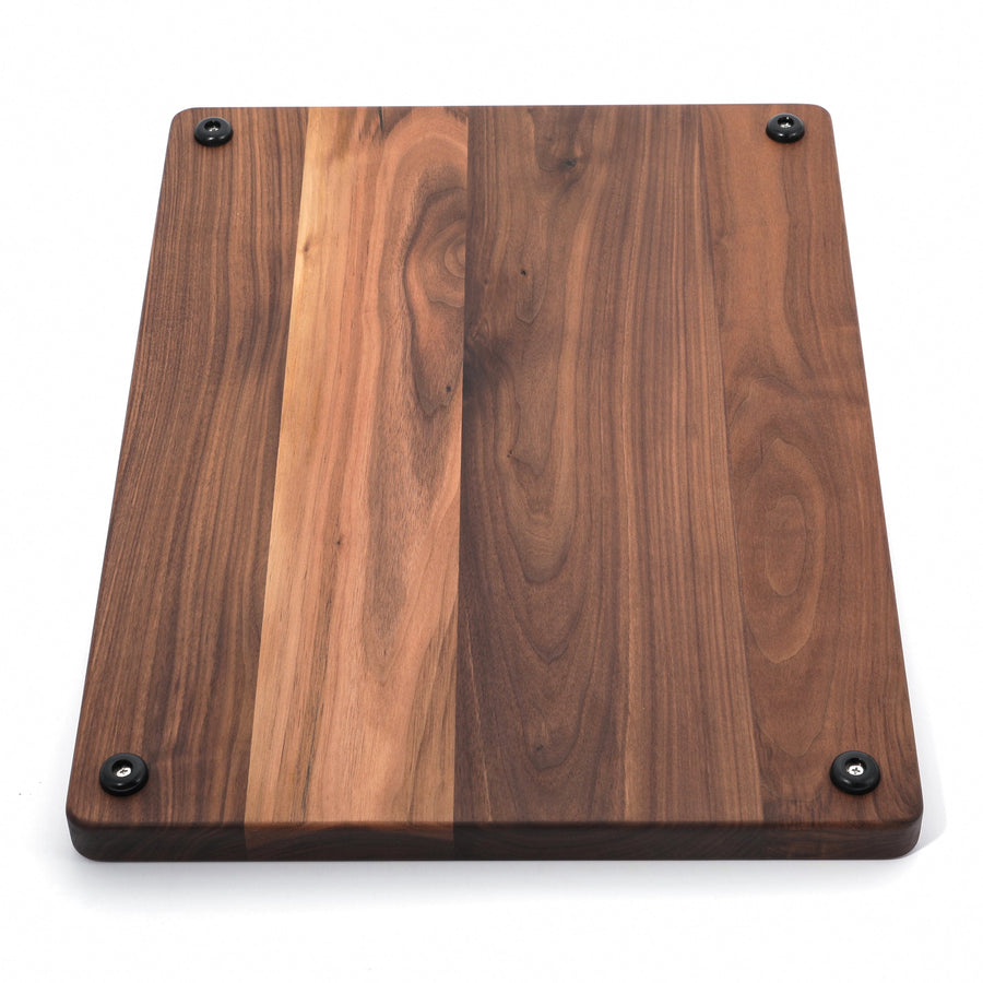 Walnut board standing upright to show underside rubber feet