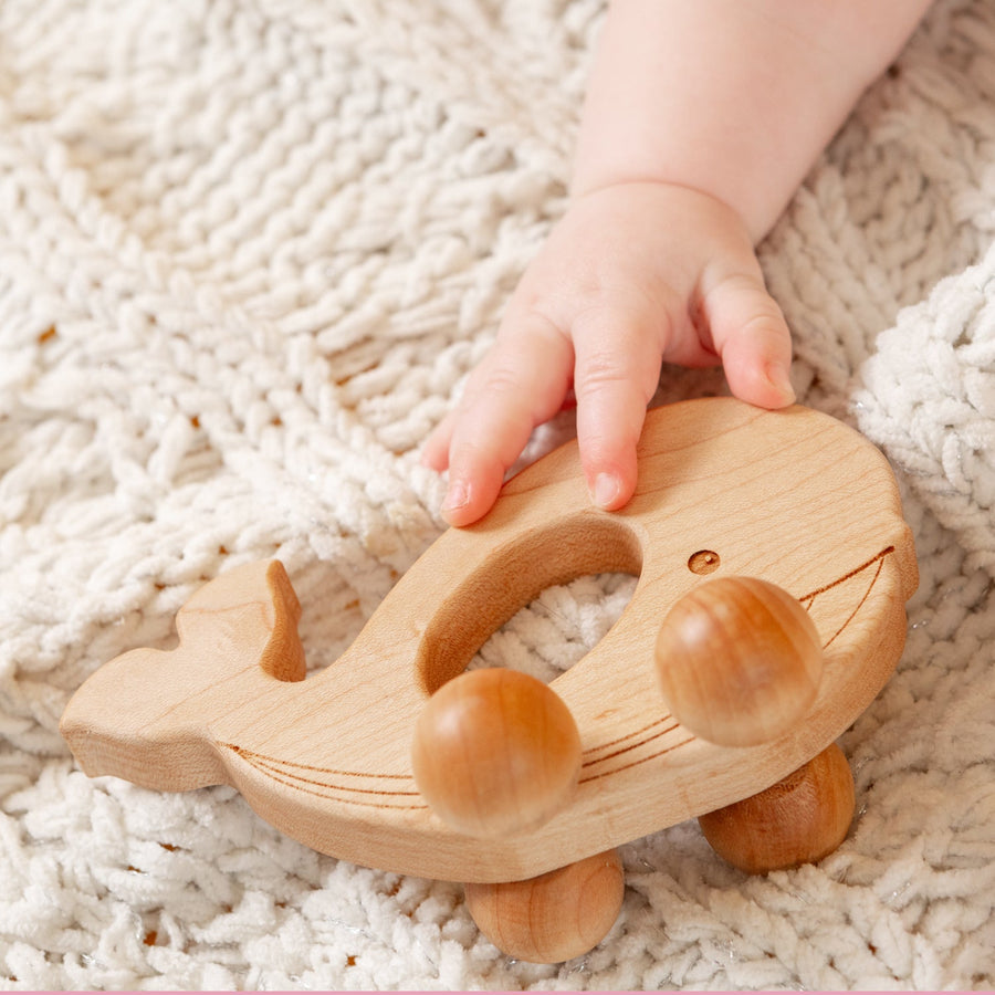 Children exploring wooden animal push toys with spherical wheels