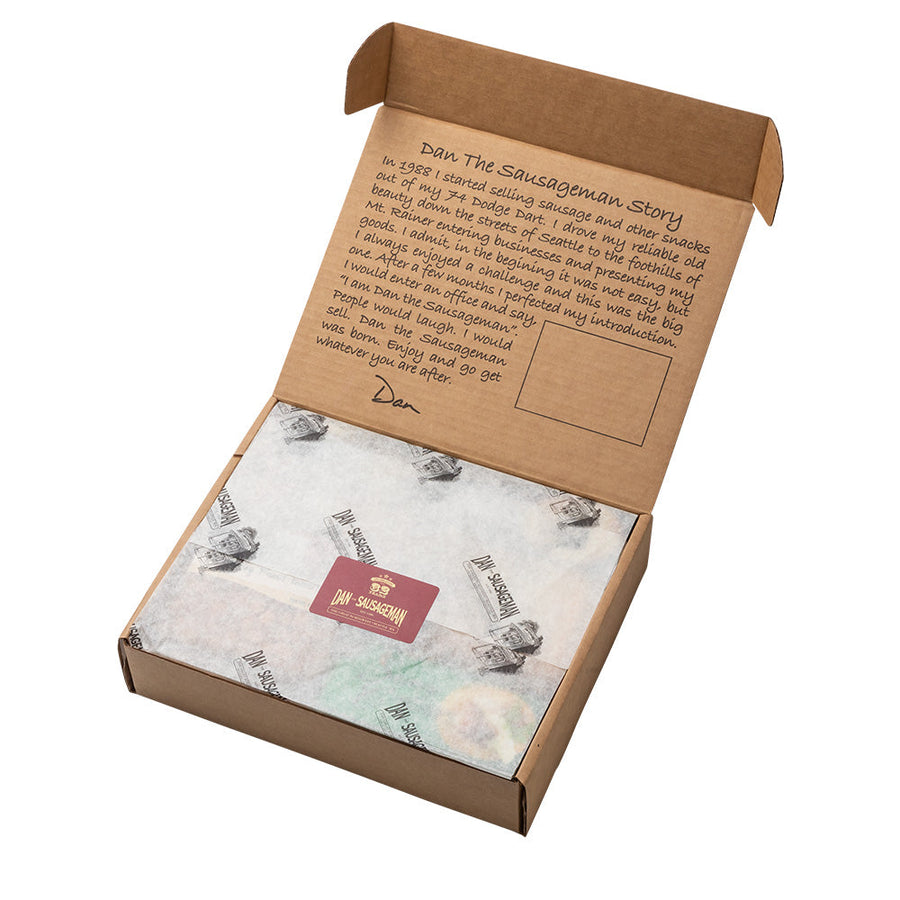 Open kraft gift box with printed tissue and a red gift tag