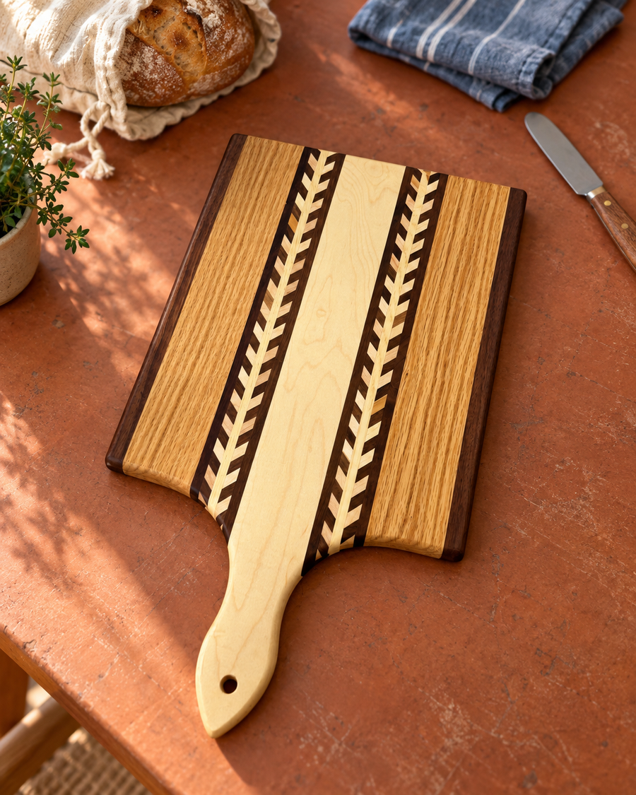 Wheat-pattern wood paddle cutting board with a shaped handle and hanging hole; styled example.