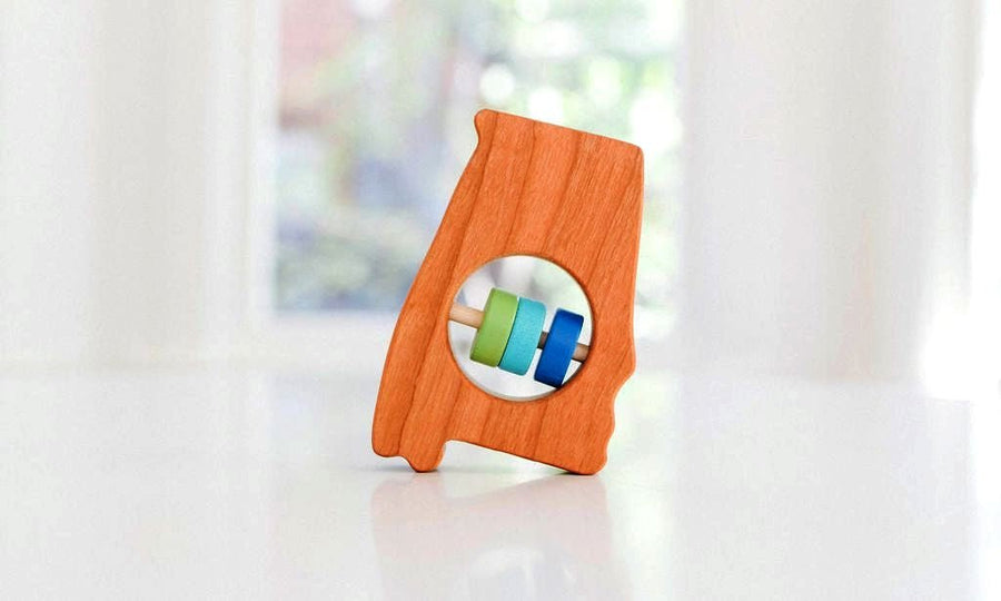 Alabama state-shaped cherry wood baby rattle with colored center disks
