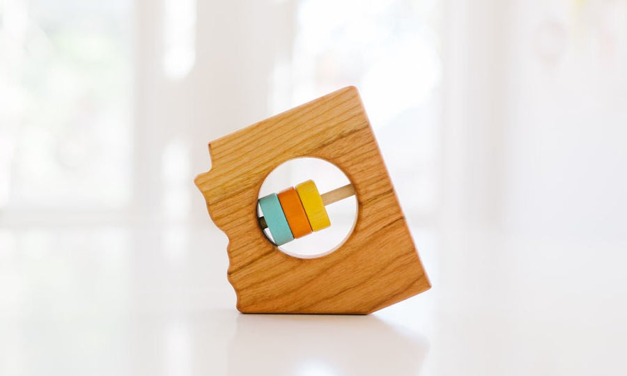 Arizona state-shaped cherry wood baby rattle with colored center disks