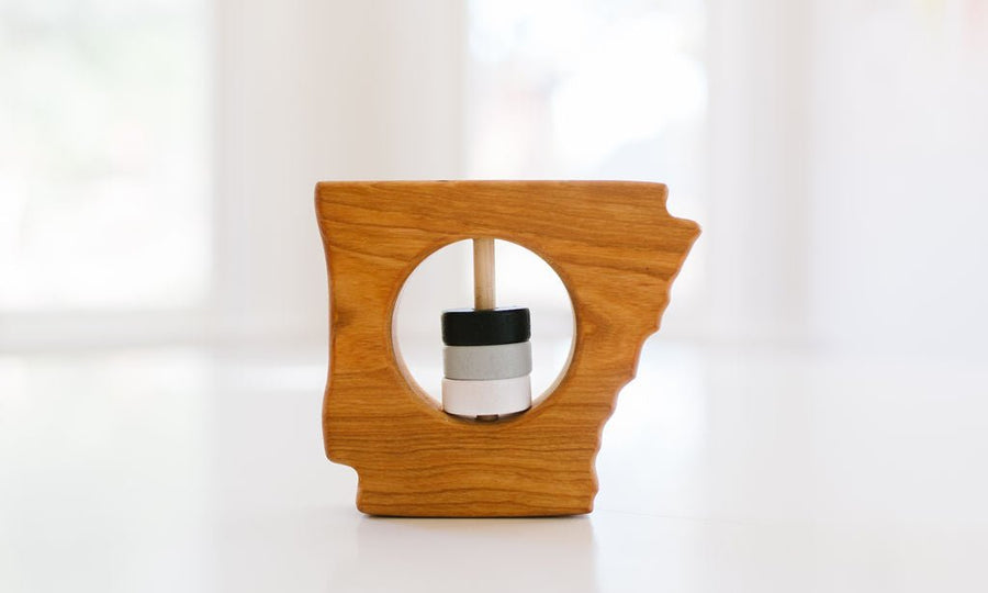 Arkansas state-shaped cherry wood baby rattle with colored center disks