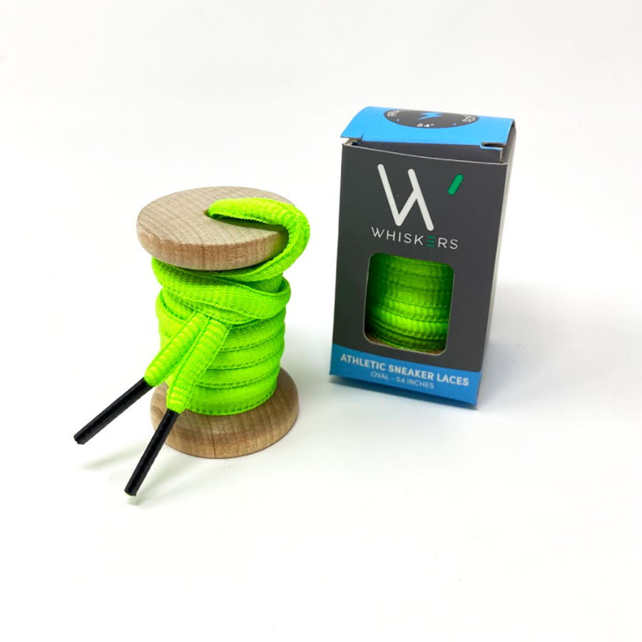 Neon Green oval athletic shoelaces on a wooden spool beside the retail box