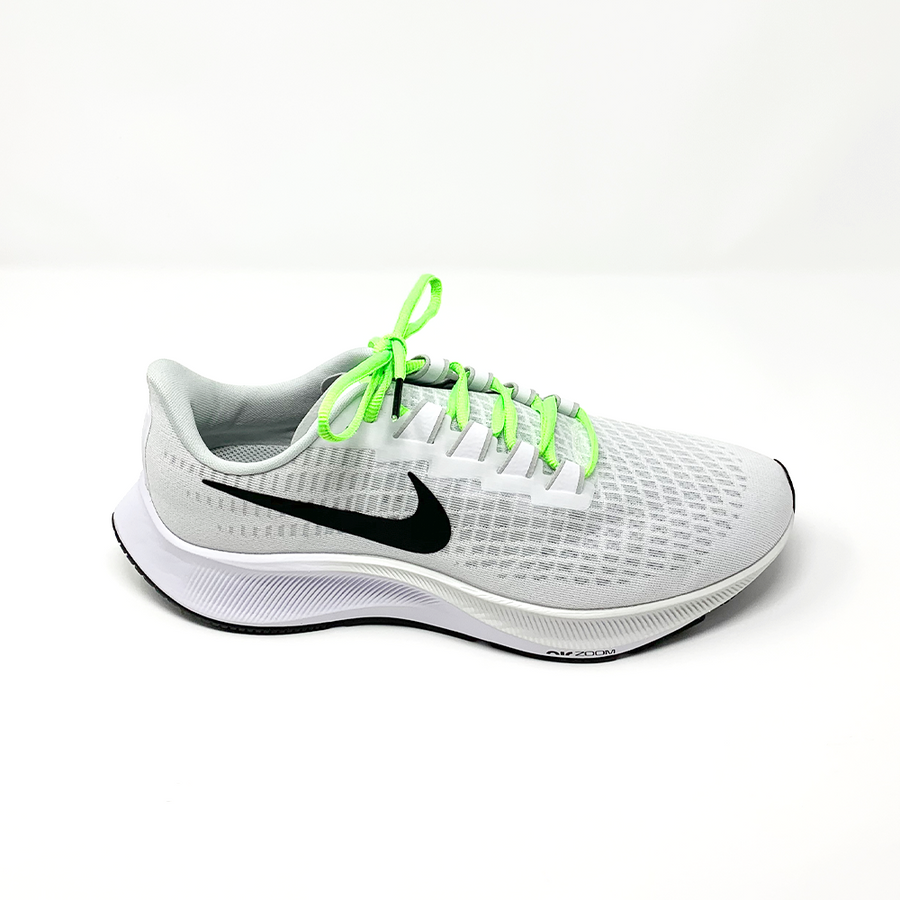 Neon Green oval athletic shoelaces laced into a light gray running shoe