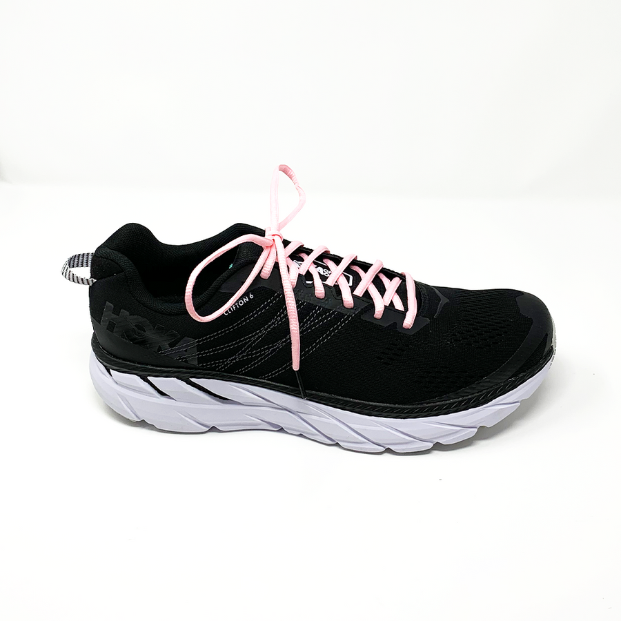 Pink oval athletic shoelaces laced into a black running shoe