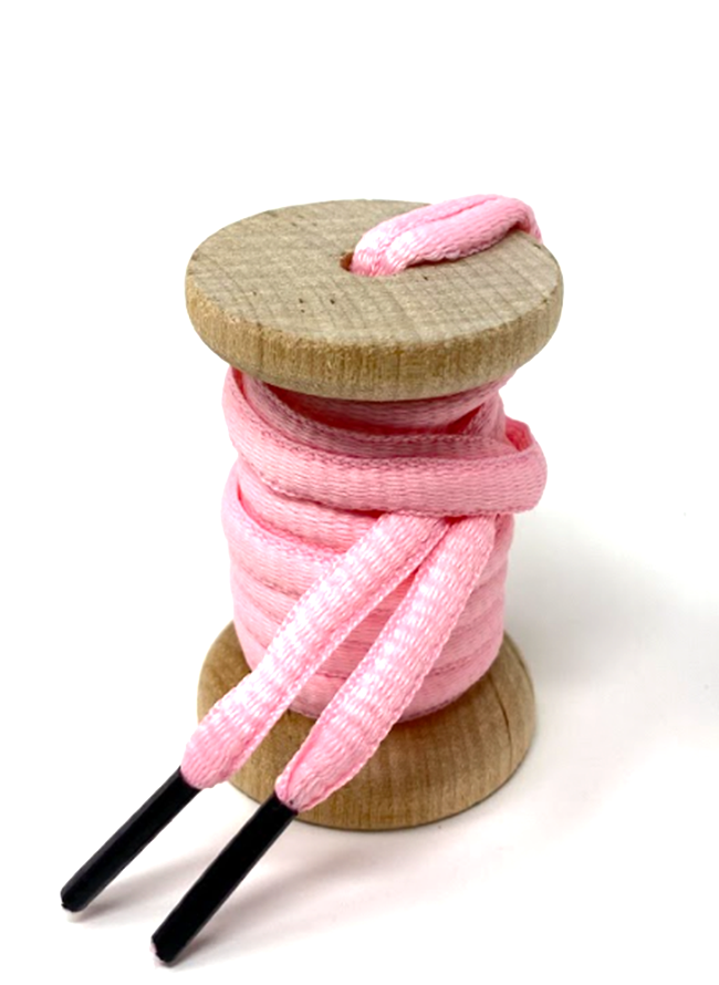 Pink oval athletic shoelaces on a wooden spool