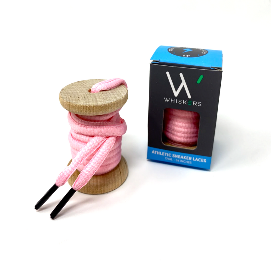 Pink oval athletic shoelaces on a wooden spool beside the retail box