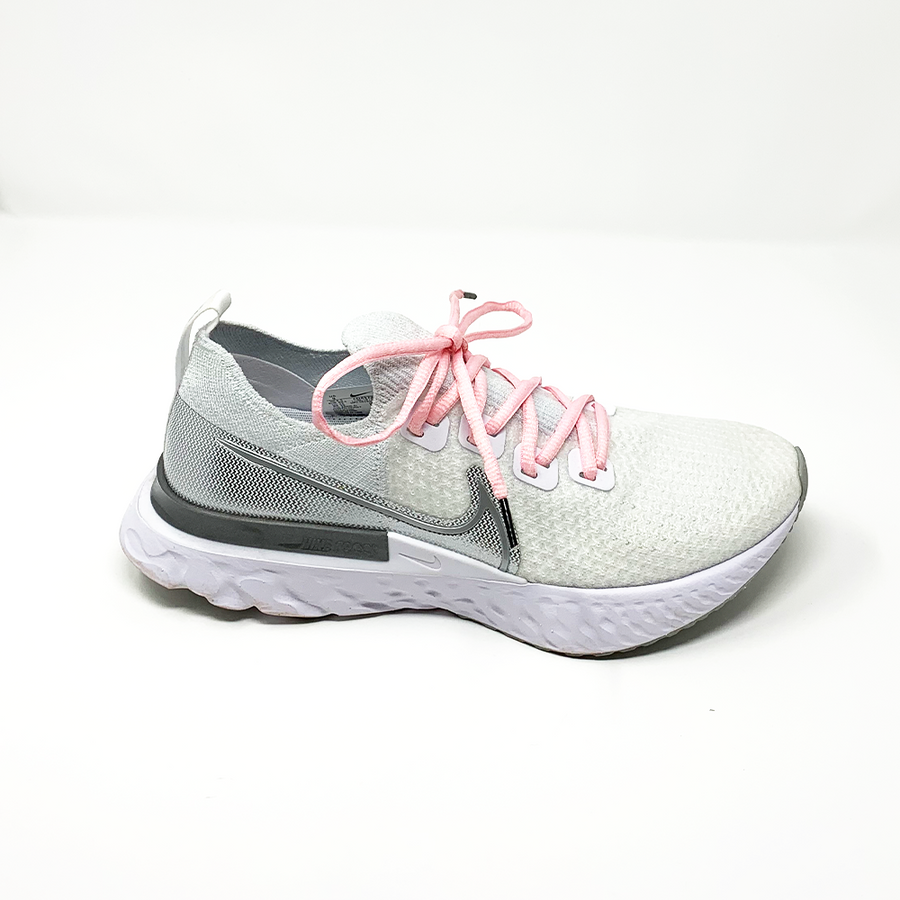 Pink oval athletic shoelaces laced into a white athletic shoe
