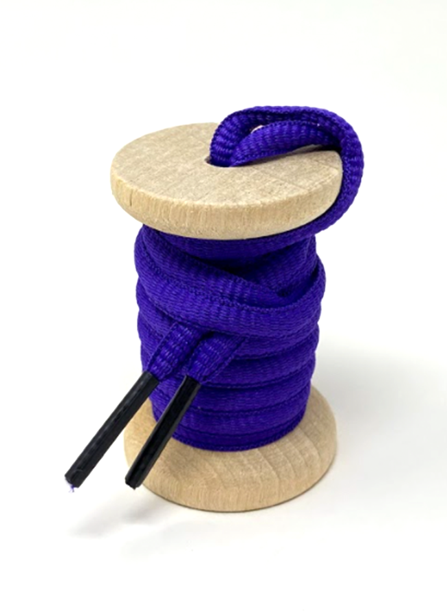 Purple oval athletic shoelaces on a wooden spool