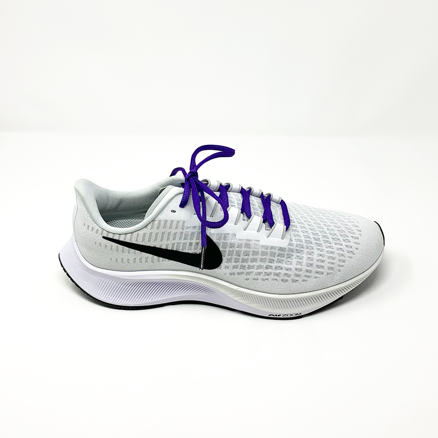 Purple oval athletic shoelaces laced into a light gray running shoe