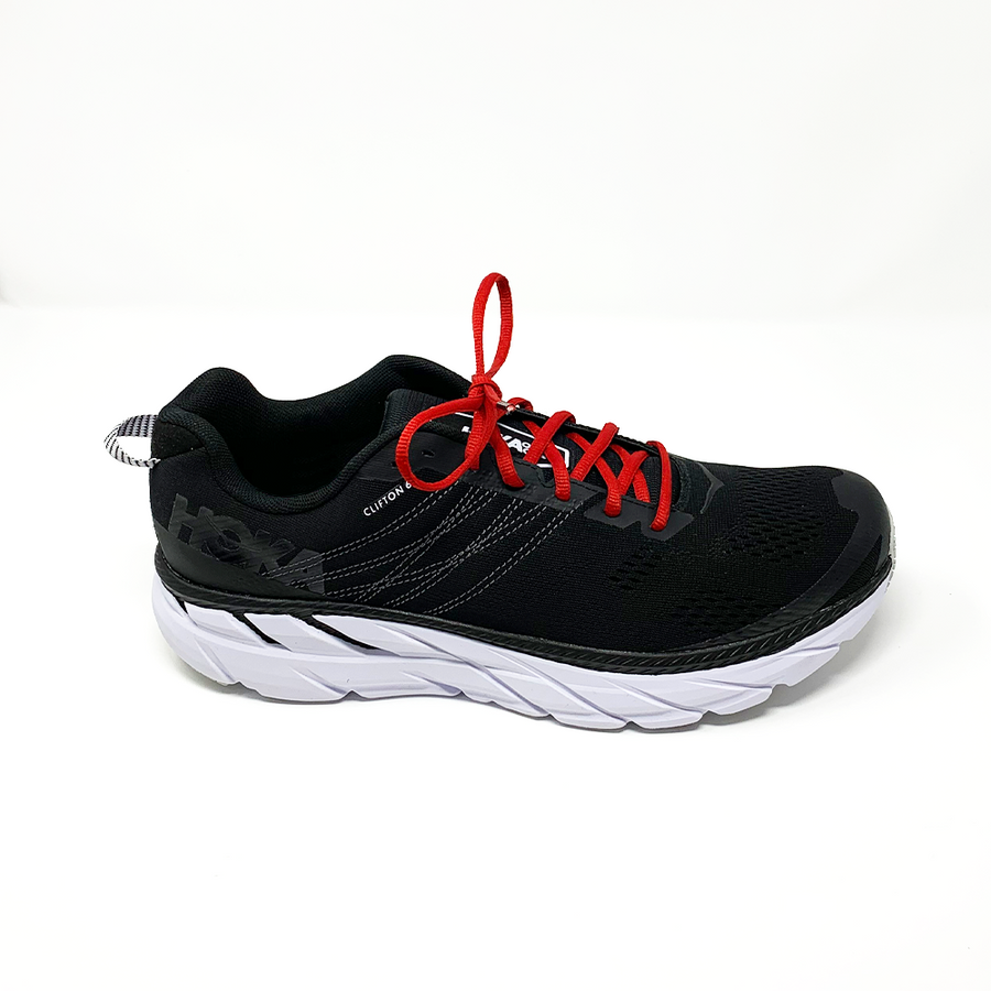 Red oval athletic shoelaces laced into a black running shoe