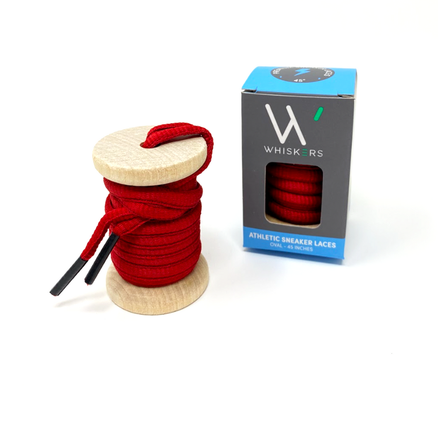 Red oval athletic shoelaces on a wooden spool beside the retail box
