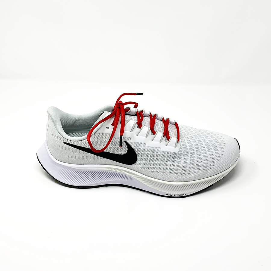 Red oval athletic shoelaces laced into a light gray running shoe