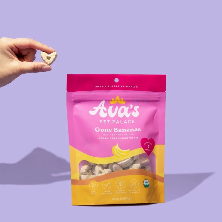 Hand holding a Gone Bananas biscuit above its bag