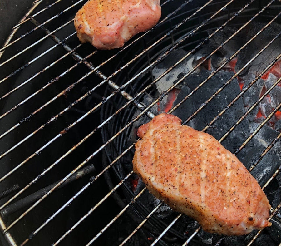 Jallelujah Jalapeño Bacon BBQ Seasoning: Seasoned pork chops cooking on a grill