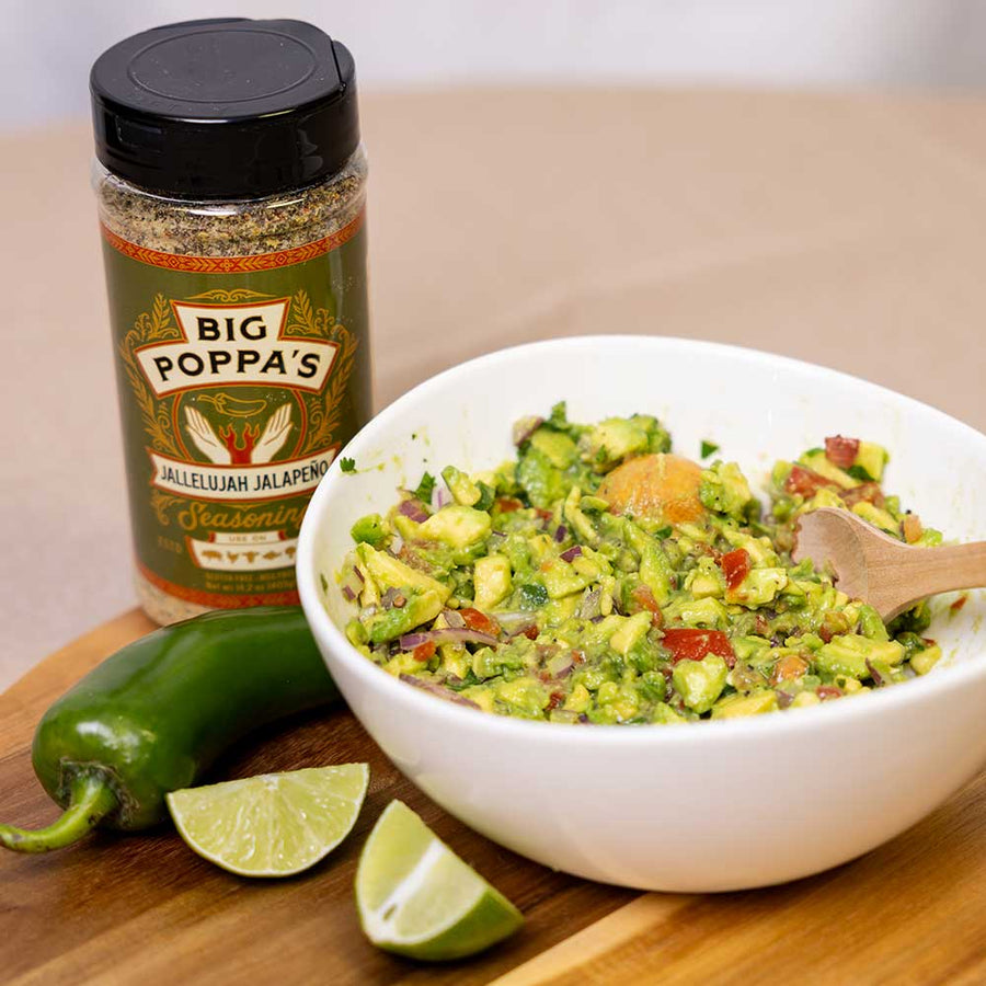 Jallelujah Jalapeño All-Purpose Seasoning: Jalapeño seasoning shaker beside guacamole, lime and peppers
