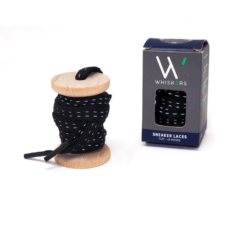Black reflective shoelaces on a wooden spool beside the retail box