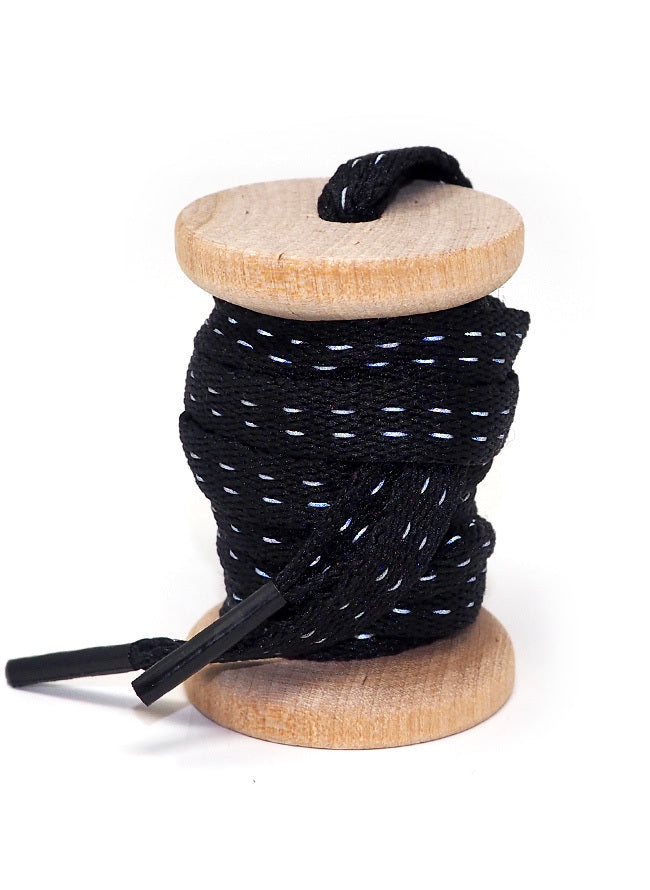 Black reflective shoelaces on a wooden spool