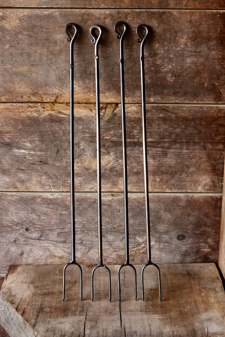 Four hand-forged campfire roasters