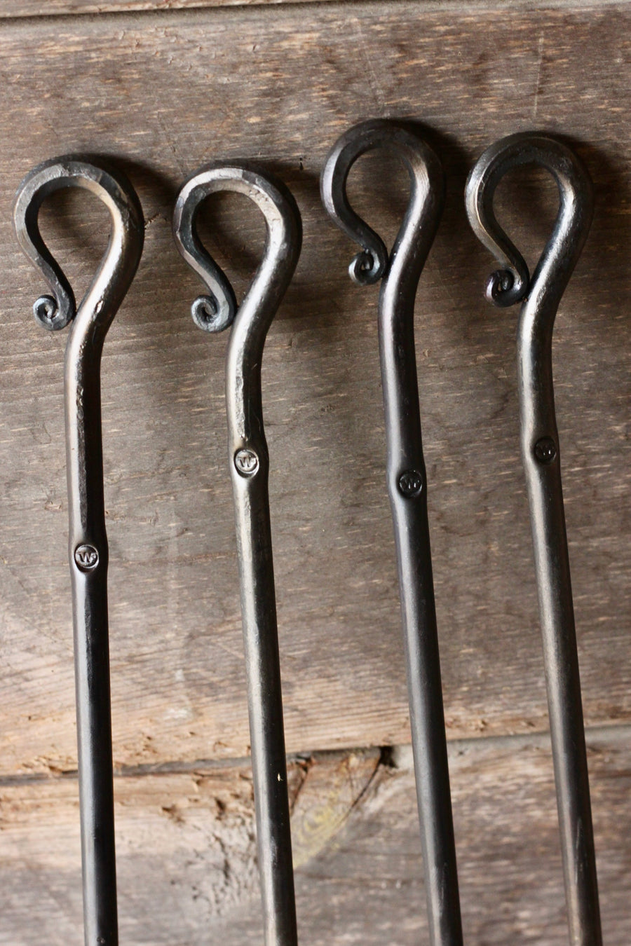 Curled handles of hand-forged campfire roasters