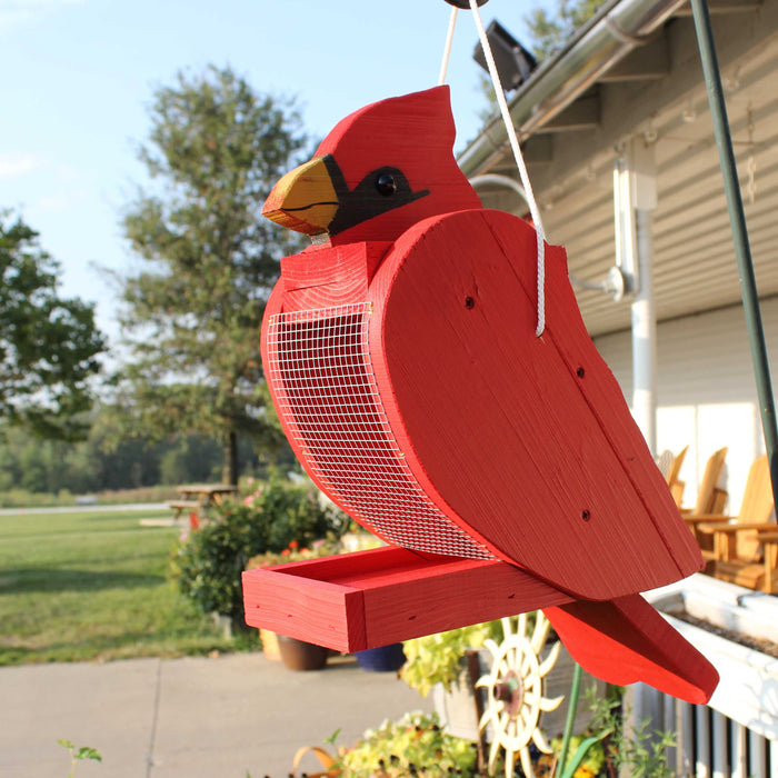 Cardinal-shaped wooden bird feeder hanging outdoors
