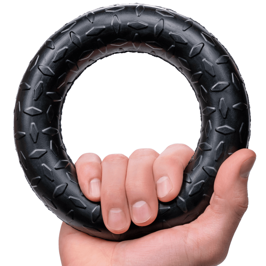 Hand holding a black textured rubber Chew Ring through the center