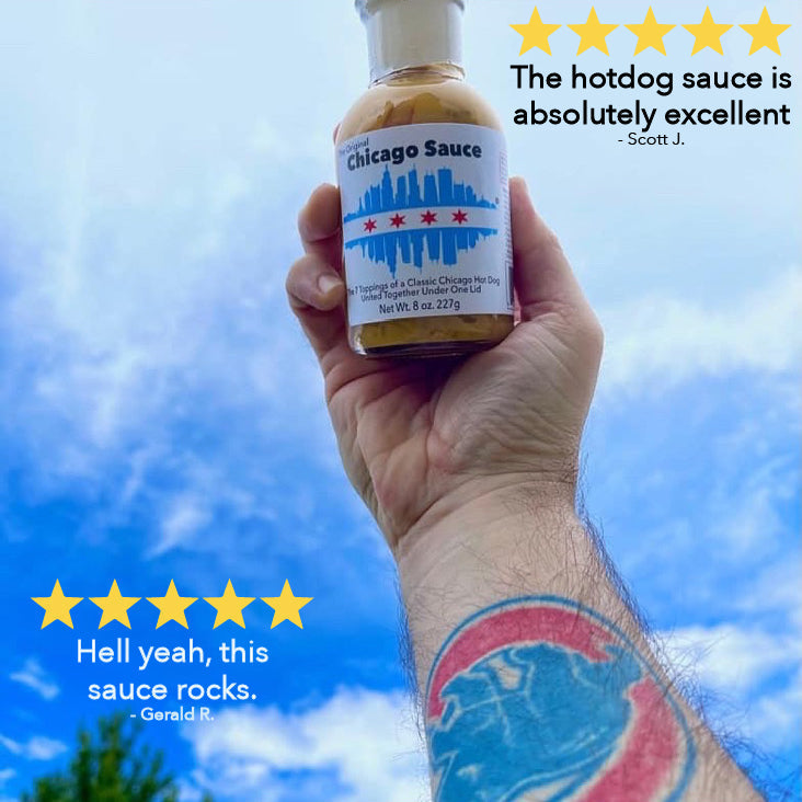 Hand holding Original Chicago Sauce against a blue sky