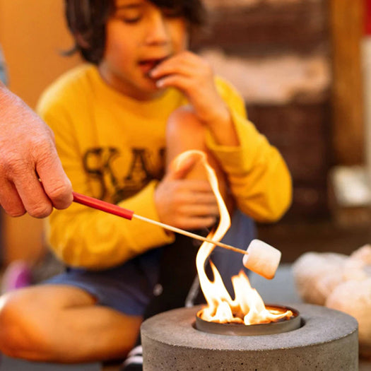 Person roasting a marshmallow over the cylinder concrete holder