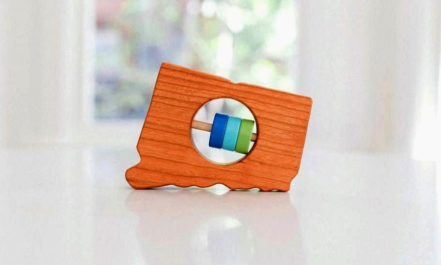 Connecticut state-shaped cherry wood baby rattle with colored center disks