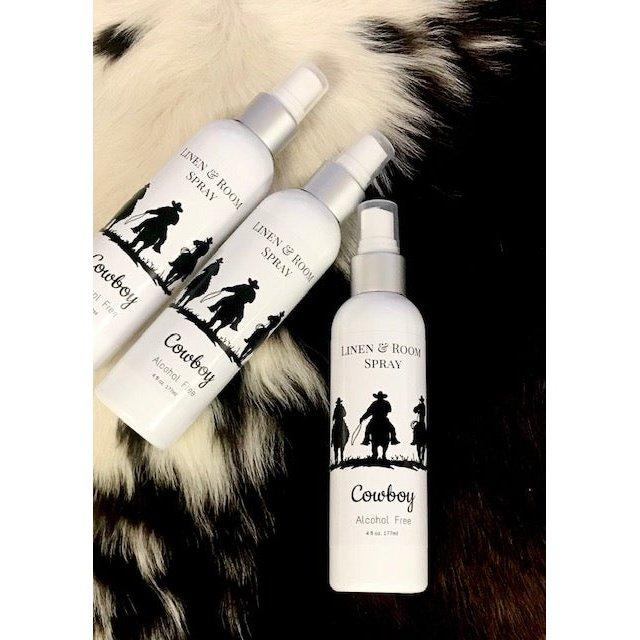 Cowboy room and linen spray bottles with Western silhouette labels displayed on cowhide