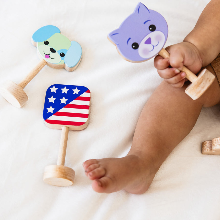 Wooden dog, cat and American flag rattles held together