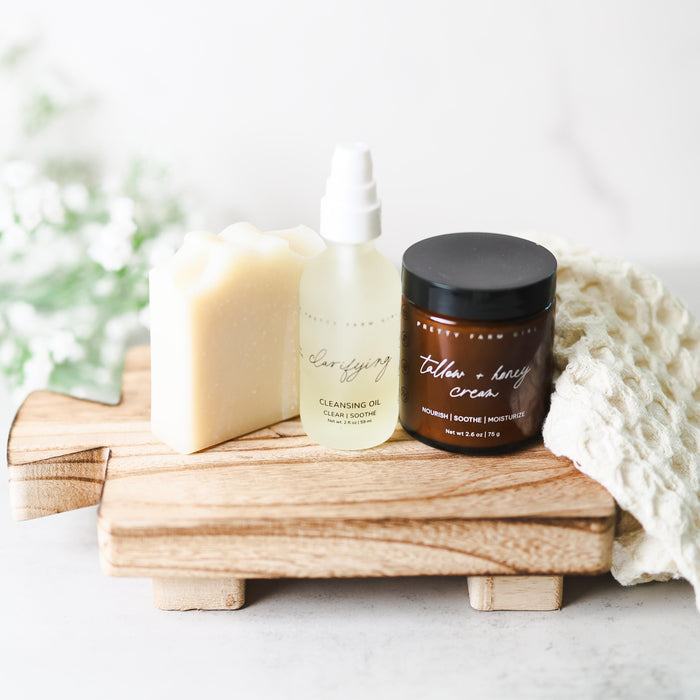 Soap, cream and facial oil bottles arranged on a wooden tray