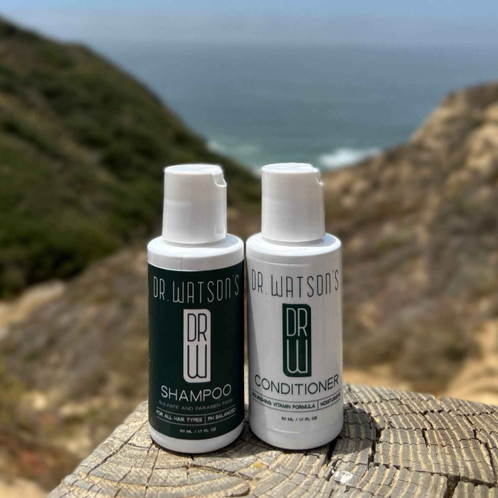 Small Dr. Watson's shampoo and conditioner bottles overlooking the coast