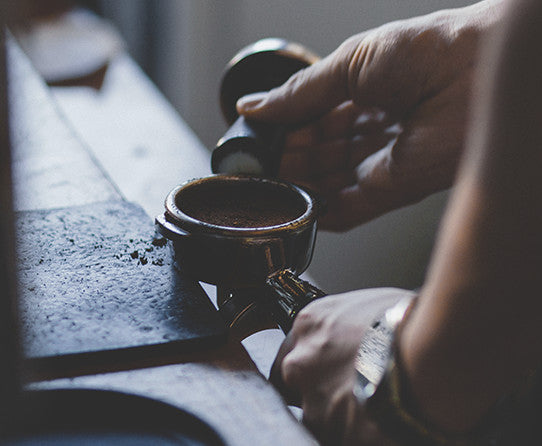 Serving suggestion: a person holding a cup of black coffee