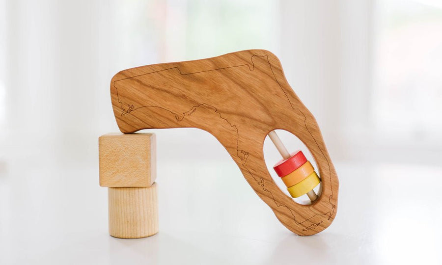 Florida state-shaped cherry wood baby rattle with colored center disks
