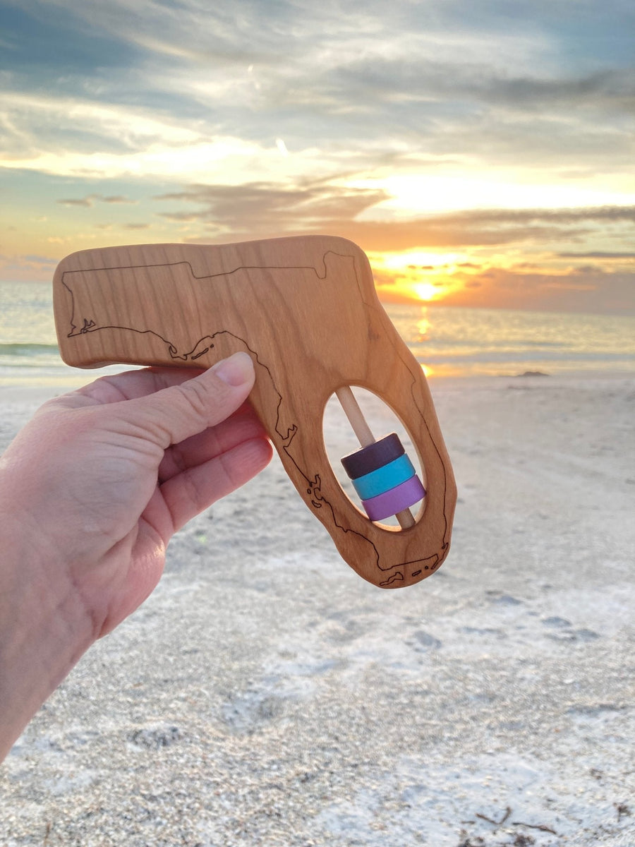 Florida state-shaped cherry wood baby rattle with colored center disks